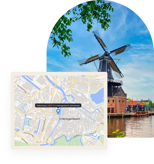 Een traditionele Nederlandse windmolen staat bovenop een stenen fundament aan een kanaal, met laagbouw en aangemeerde boten op de achtergrond onder een helderblauwe lucht met verspreide wolken.